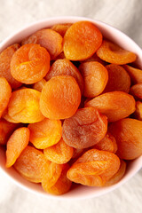 Raw Dry Apricots in a Bowl, top view. Flat lay, overhead. Close-up.
