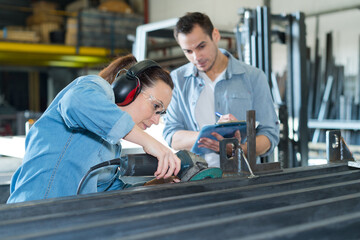 couple of workers in uniform near milling machine at factory
