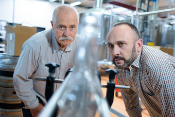 distillery workers observing the machine