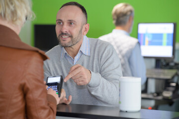 man paying bill through smartphone using nfc technology in cafe