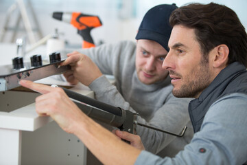 two men installing a new kitchen hob