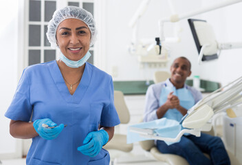 Portrait of female dentist in medical center standing near the chair
