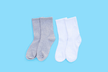 Grey and white socks on blue background.