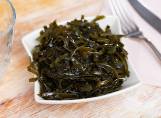 Natural seaweed salad served in bowl to table