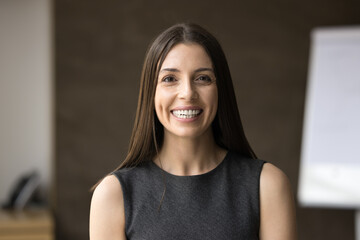 Cheerful attractive business coach woman head shot video call portrait. Happy Latin businesswoman, female professional posing in office boardroom, looking at camera with toothy smile