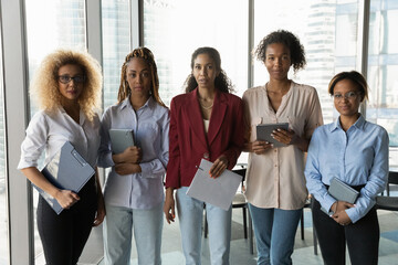 Professional work. Confident mixed race businesswomen look at camera lined up in row for team...
