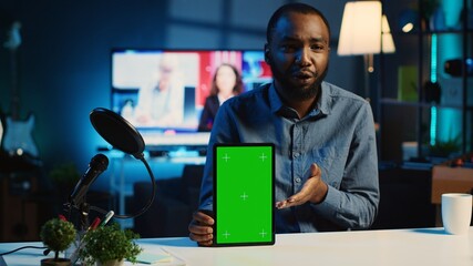 Tech content creator filming green screen tablet unboxing, giving reasons to purchase it. Influencer recording video urging subscribers to buy sponsoring partner mockup digital device - obrazy, fototapety, plakaty