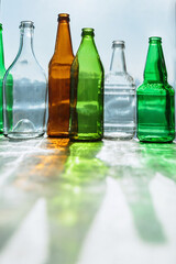 Empty bottles with creative shadows and fantastic highlights. Wastes of different glass containers ready for recycling. Separate collection of glass garbage. Eco friendly and zero waste concept