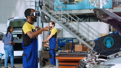 Certified engineer in repair shop using advanced virtual reality technology to visualize car...