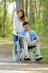 young lady pushing disabled young man in wheelchair