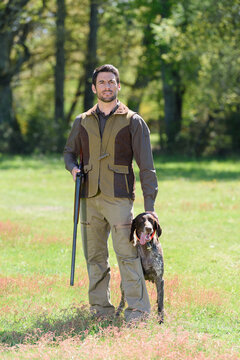 portrait of hunter with dog outdoors