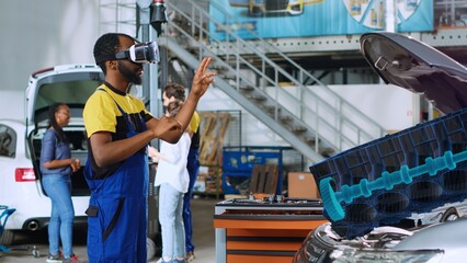Technician in repair shop using advanced virtual reality technology to visualize car engine turbine...