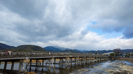 Historic wooden bridge crosses river to Arashiyama in Kyoto, Japan