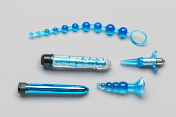 Different blue sex toys on grey background