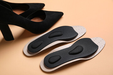 Obraz premium Stylish high heeled shoes and orthopedic insoles on color background, closeup
