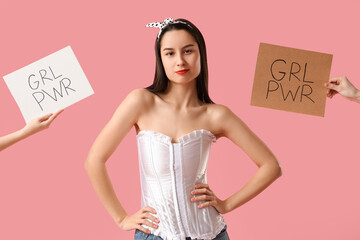 Portrait of young pin-up woman with GRL PWR signs on pink background. Women's History Month