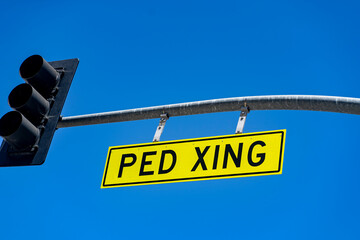 Ped xing sign on a blue sky background