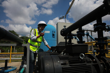 Young female engineer check water pump and water treatment system, industrial and factory concept