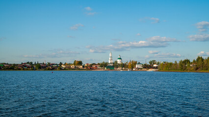 Fototapeta premium a beautiful blue lake with a village and a church on the horizon