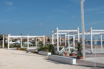 marzamemi sicily italy boardwalk harbor docks white post pillar structures by water ocean