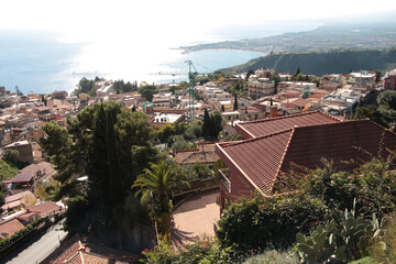 taormina sicily italy wide shot homes houses buildings on mountain cliff hill next to ocean water...