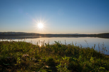 a beautiful warm sunset and a picturesque landscape with a lake