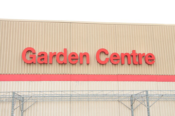 garden centre writing caption text on beige wall building above red line in red writing exterior...