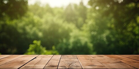 Ideal for photo editing or showcasing products, an empty wooden table with a blurred green forest background and bokeh effect. - obrazy, fototapety, plakaty