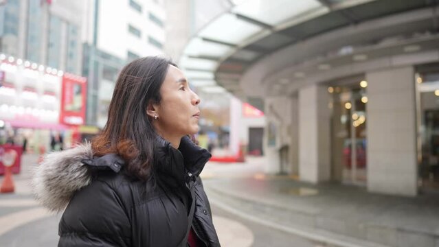 寒い冬に韓国のソウルの明洞のメインストリートを歩く30代の韓国人男性のスローモーション映像 Slow-motion video of a Korean man in his 30s walking on the main street of Myeong-dong, Seoul, South Korea in the cold winter