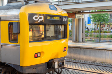 Yellow public transport train bound for Cais do Sodré stopped at Cais do Sodré train station in...