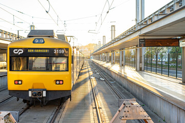 railway station with train carriages on the left and a deep corridor on the right.