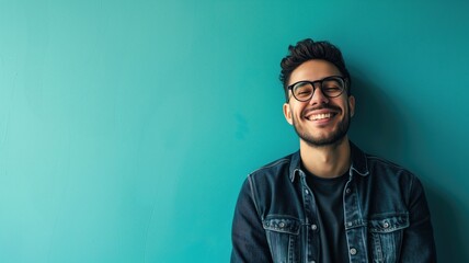Cheerful man in denim jacket against a turquoise background