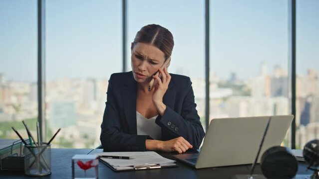 Frustrated employee speaking mobile phone at desk. Stressed woman check papers