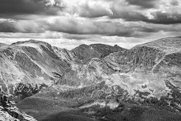 Classic Black and white Rocky Mountain landscape with dark storm clouds over the valley and forest environment of Rocky Mountain National Park Colorado. 