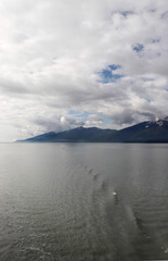 Sky scape with clouds over distant shore from the ocean.