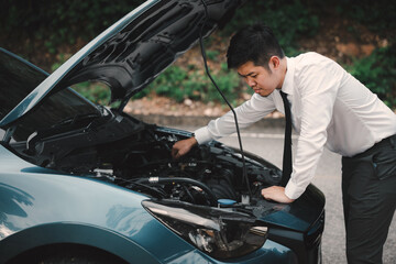 Asian businessman car broken breakdown, angry young stressed man stands trouble car failure problem looking in frustration at failed engine in morning, accident on road outdoor, late for business work