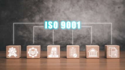 ISO 9001 concept, Wooden block on desk with iso 9001 icon on virtual screen.