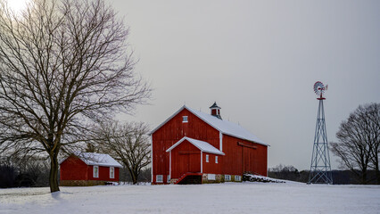Winter rural road travel landscape in New England of America with bare trees, snow-covered hills, and barns © Naya Na