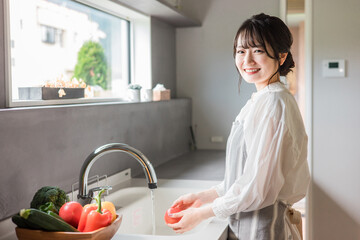 キッチンで料理・家事をする若いアジア人女性（自炊・朝食・ランチ）
