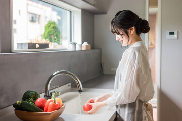 キッチンで料理・家事をする若いアジア人女性（自炊・朝食・ランチ）  © buritora