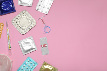 Contraceptive pills, condoms, intrauterine device and thermometer on pink background, flat lay and...