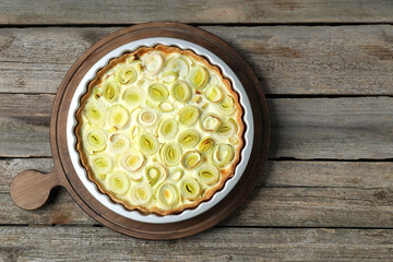Freshly baked leek pie on old wooden table, top view. Space for text