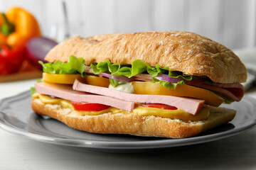 Tasty sandwich with boiled sausage, cheese and vegetables on white wooden table, closeup