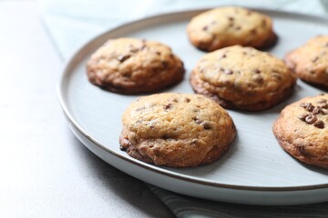 Plate with delicious chocolate chip cookies on table, closeup