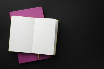 Notebooks on black background, top view. Space for text