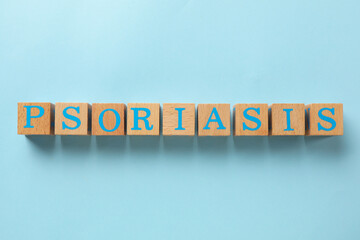 Word Psoriasis made of wooden cubes with letters on light blue background, top view