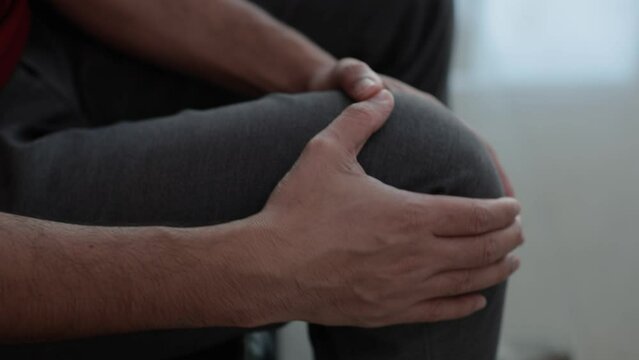 Hands massaging knees to relieve pain