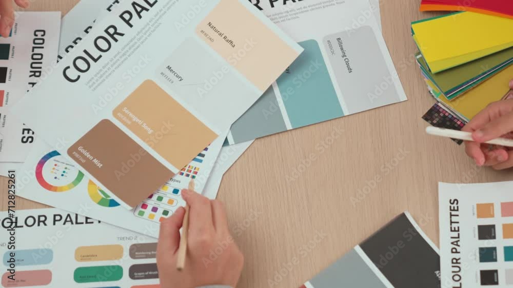 Poster top view hand closeup on workspace table of two designer choosing color for graphic design working o