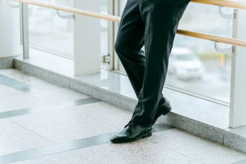 Foto op Plexiglas ロビーで待ち合わせするスーツ姿の男性の足元（革靴・ビジネスマン・ロビー）  © buritora