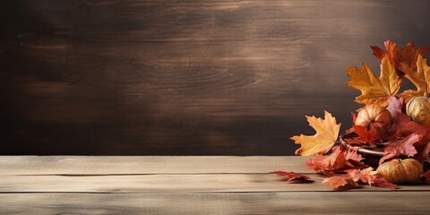 Obraz premium Fall-themed backdrop featuring wooden table adorned with dried leaves, ideal for showcasing products.
